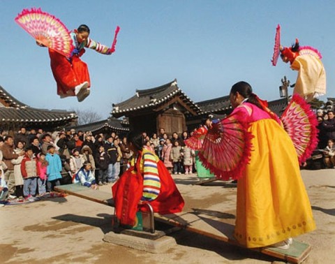 South Korean students wearing traditional dress play on a seesaw, Korean traditional game, to celebrate the Lunar New Year at the Korean Folk village in Seoul, South Korea, Saturday, Jan. 24, 2004. About 32 million people or 60 percent of the population are expected to head for their hometowns nationwide to celebrate Chinese New Year. (AP Photo/Ahn Young-joon)